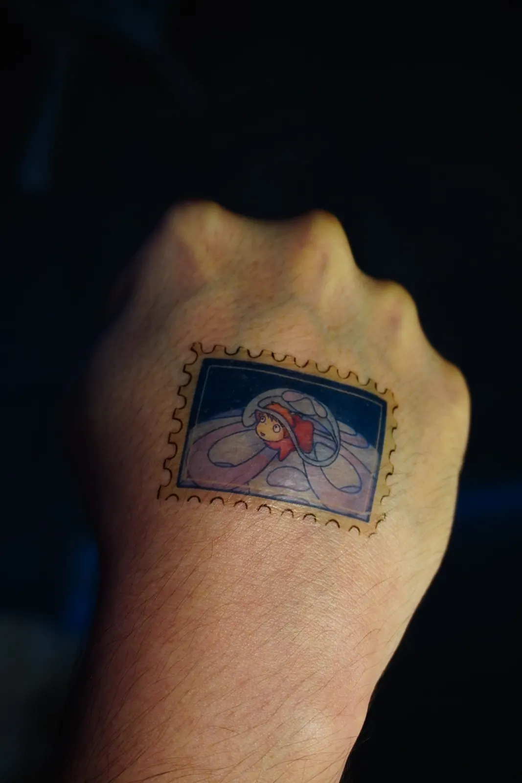 Tatuaje temporal en forma de estampilla con Ponyo, aplicado en el dorso de la mano