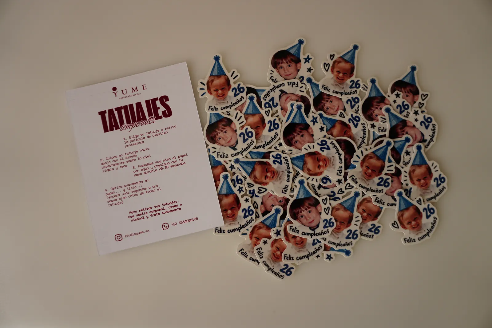 Tatuajes temporales de cumpleaños ya recortados junto a la tarjeta de instrucciones de Yume