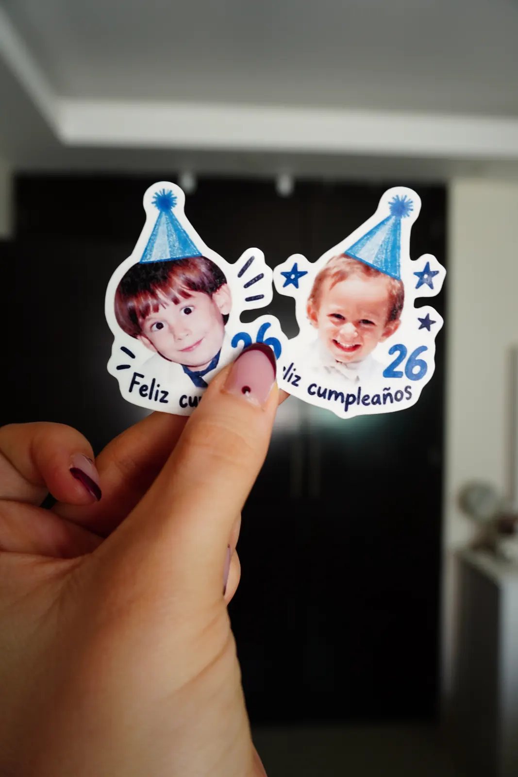 Dos tatuajes temporales de cumpleaños con fotos de infancia, sostenidos en la mano