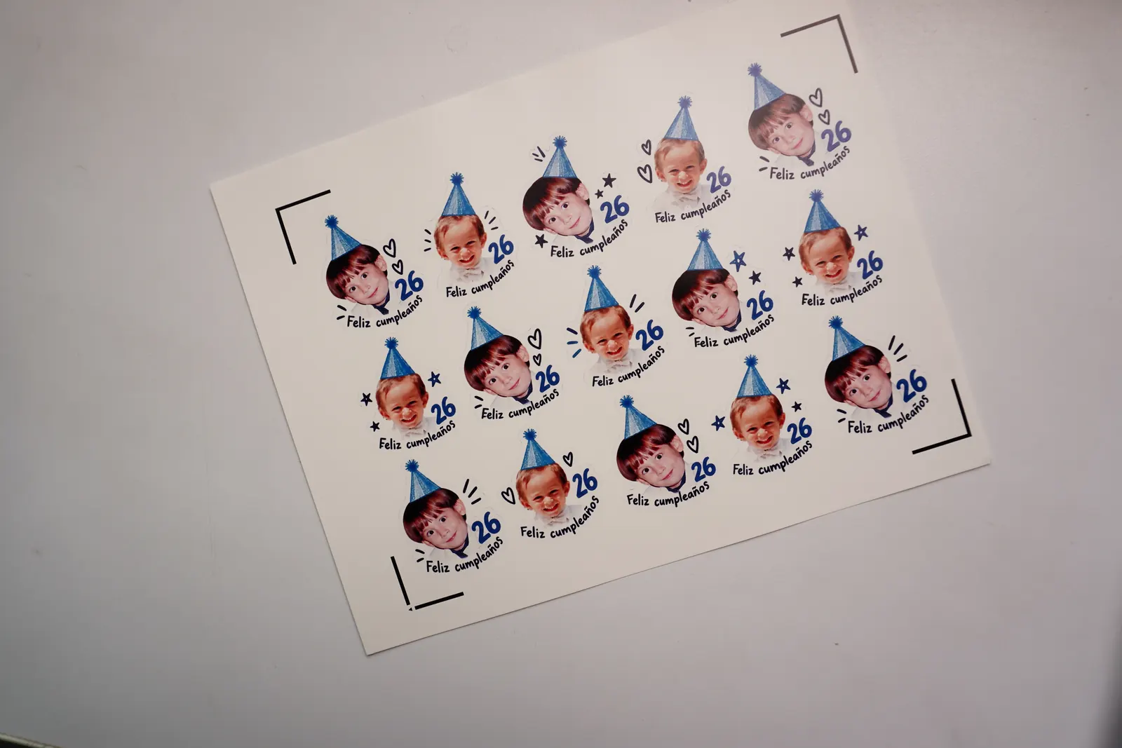 Hoja de tatuajes temporales con fotos de infancia, gorro azul y el texto Feliz cumpleaños 26