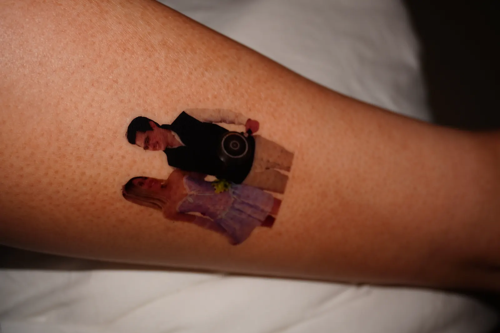 Tatuaje temporal con la foto recortada de una pareja, aplicado en el antebrazo