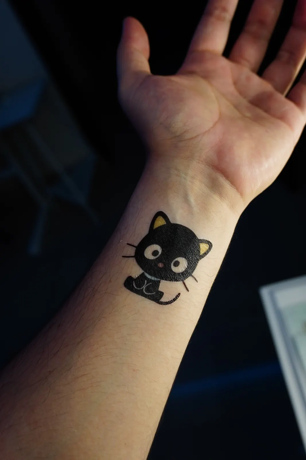 Tatuaje temporal de Chococat, el gato negro de Sanrio, aplicado en la muñeca